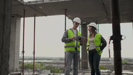 Ingenieure-oder-Architekten-diskutieren-auf-der-Baustelle-über-den-Bebauungsplan.-contre-jour.-Ingenieure-oder-Architekten-diskutieren.