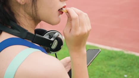 Lifestyle-asiatische-Sportfrauen-halten-Smartphone-spielen-Musik-Entspannung