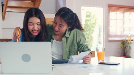 Business-Asian-Lesben-Paar-mit-Taschenrechner-Rekord-Budget,-Steuer,-Finanzdokument-auf-Laptop-in-der-Küche-arbeiten.