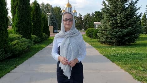 Mujer-ortodoxa-caminando-en-el-Parque-en-el-fondo-de-la-Iglesia