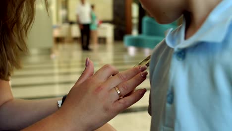 Close-up-of-a-girl-holding-a-phone-in-the-hotel,-and-child-looks-into-the-screen