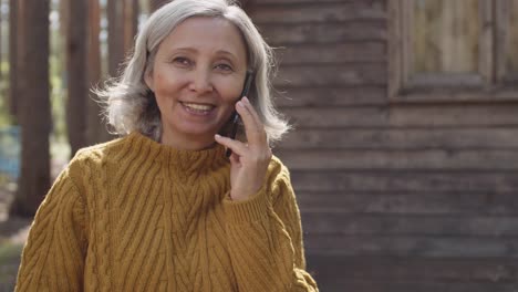 Mujer-envejecida-hablando-por-teléfono-en-el-campamento-turístico