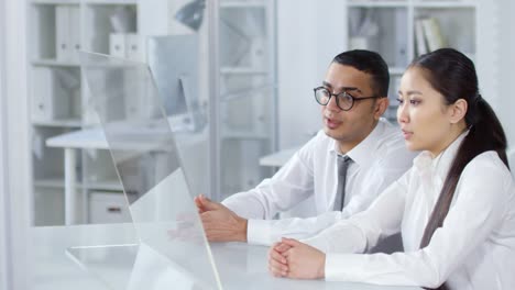 Arab-Man-and-Asian-Woman-Using-Transparent-AR-Touchscreen