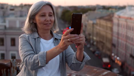 Pretty-Aged-Woman-Making-Photos-auf-dem-Dach