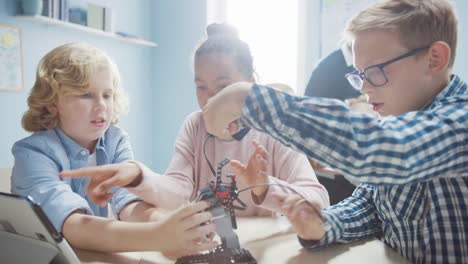 Elementary-School-Robotics-Classroom:-Diverse-Group-of-Children-Building-and-Programming-Robot-Together,-Talking-and-Working-as-Team.-Kids-Learning-Software-Design-and-Creative-Robotics-Engineering