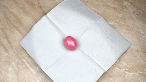 Man-puts-on-a-napkin-the-Easter-dyed-and-painted-colored-egg-during-a-Pascha-or-Resurrection-Sunday