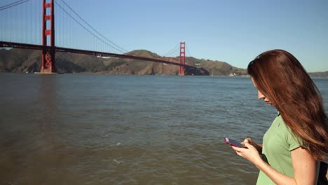 Mujer-usando-smartphone-junto-al-puente-Golden-Gate