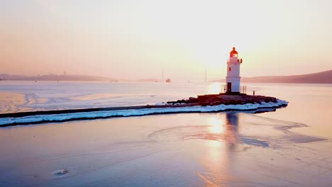 Aerial-winter-view-of-the-Tokarevskiy-lighthouse---one-of-the-oldest-lighthouses-in-the-Far-East,-still-an-important-navigational-structure-and-popular-attractions-of-Vladivostok-city,-Russia.