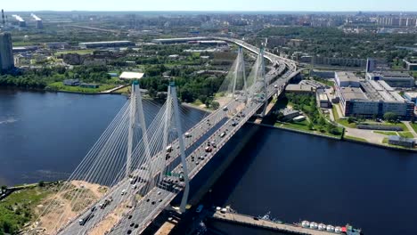 Aerial-or-top-view-from-drone-of-concrete-bridge-with-asphalt-road-or-highway-over-big-river-with-city-car-traffic,-urban-transportation,-toned