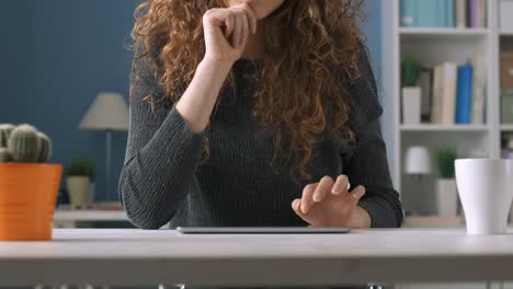 Young-woman-using-a-tablet-and-smiling-at-camera