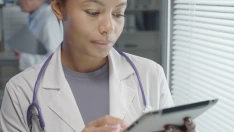 Mixed-Raced-Female-Doctor-Surfing-the-Internet-on-Digital-Tablet