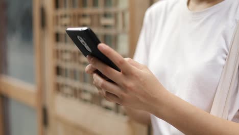 Close-up-woman-using-smartphone-chatting-with-friends.