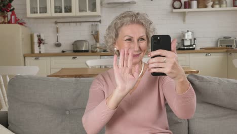 Retired-woman-speaks-and-smiles-into-smartphone-camera