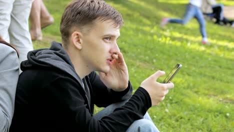 Man-looking-for-information-on-a-smartphone-in-the-park