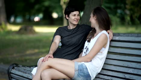 Lesbianas-dos-chicas-relax-en-el-parque-en-un-banco