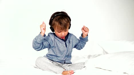 4-year-old-boy-in-bed-with-headphones-playing-with-the-tablet