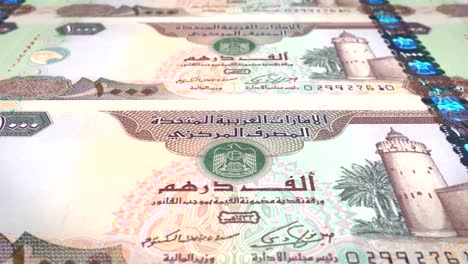 Banknotes-of-one-thousand-dirhams-arabs-of-the-bank-of-the-Arab-Emirates-rolling-on-screen,-coins-of-the-world,-cash-money,-loop