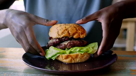 Young-man-tries-to-eat-a-huge-hamburger