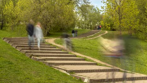 personas-a-pie-las-escaleras-en-el-parque-de-la-ciudad-en-primavera,-lapso-de-tiempo