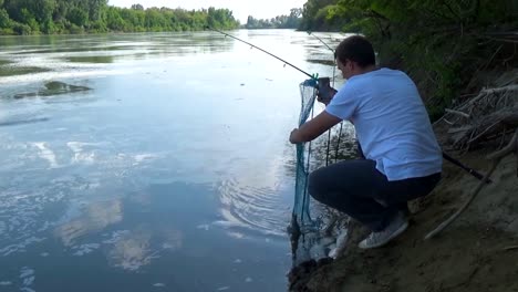 The-fisherman-photographs-the-fish-on-a-smartphone-for-placement-in-social-networks.-A-man-takes-pictures-of-his-catch-for-instagram