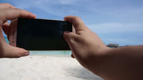 Toma-POV-de-un-teléfono-inteligente-tomar-foto-en-la-mano-del-turismo.-Divertirse-en-vacaciones-mar