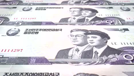 Banknotes-of-five-wons-of-North-Korea-rolling,-cash-money,-loop