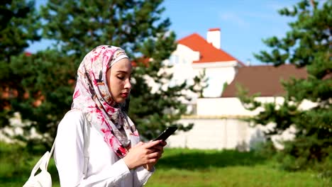 Muslim-girl-using-cell-on-the-go