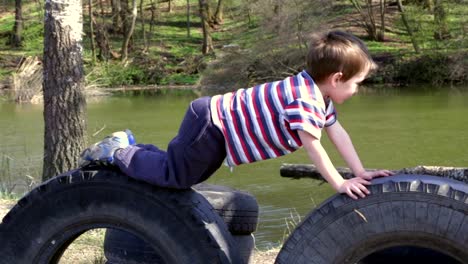 Two-kids-playing-together-on-tires-in-playground