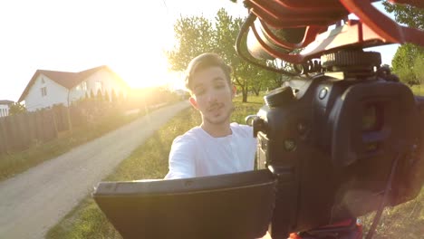 Vlogger-nervioso-caminando-y-quejarse-de-sus-vecinos-ruidosos-durante-el-rodaje-de-sí-mismo-con-una-cámara-profesional-móvil-en-la-naturaleza