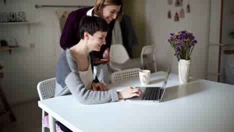 Female-students-searching-internet-on-laptop-computer.-Two-woman-looking-news