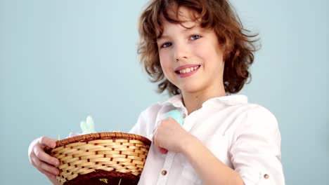 Muchacho-con-cesta-de-Pascua.-Adolescente-muestra-en-su-mano-tendida-un-suavemente-azul-huevo-de-Pascua