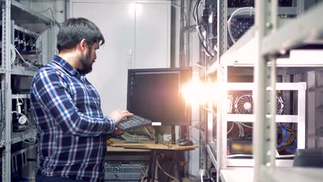 Male-programmer-is-holding-a-keyboard-and-following-cryptocurrency-mining-process