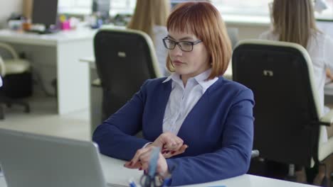 Disabled-Businesswoman-Riding-Wheelchair-and-Working-on-Laptop-in-Office