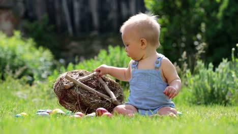 Niedlichen-Kind,-spielt-mit-kleinen-Häschen-und-Ostern-Eier-in-einen-blühenden-Garten,-Frühling.-Junge-mit-Kaninchen-spielen,-Ei-Jagd-für-Urlaub