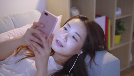 Asian-woman-using-cellphone-in-living-room