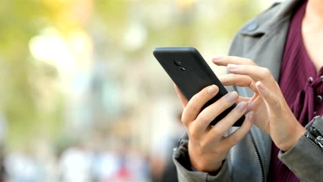 Mujer-manos-navegación-contenido-del-teléfono-en-la-calle