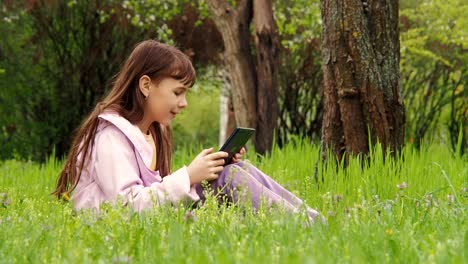 Videoanruf.-Ein-Kind-mit-einem-Tablet-in-der-Wiese