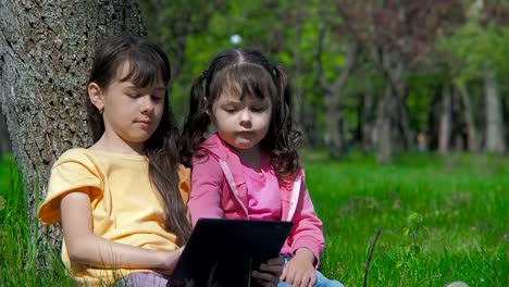 Niños-con-una-tableta-sobre-la-naturaleza.