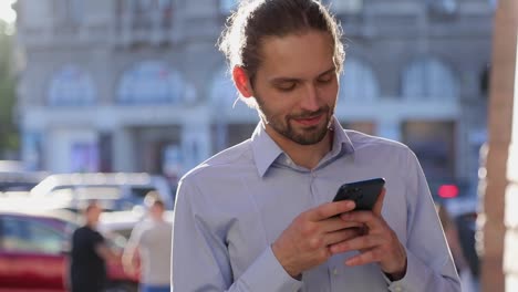 Business-Mann-mit-Handy-auf-Straße-an-sonnigen-Tag