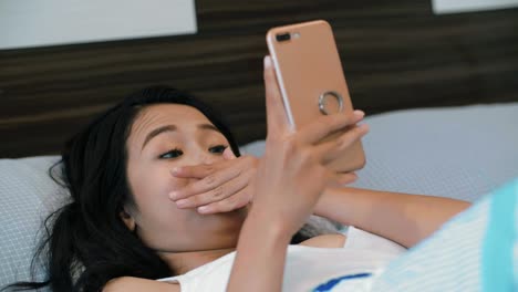 Woman-Using-Smartphone-In-Bed