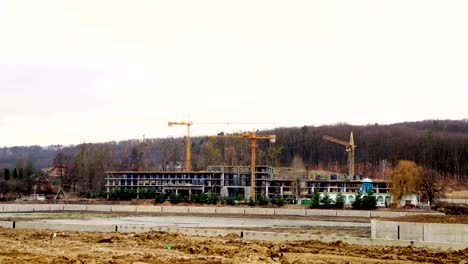 Industria-de-la-construcción-timelapse.-Tres-grúas-y-un-grupo-de-trabajadores-están-construyendo-una-casa.