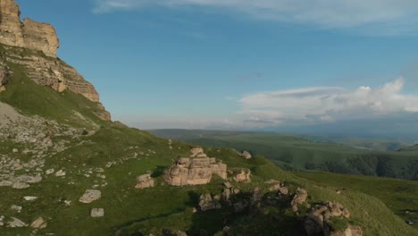 Flying-above-a-large-rock-formation-standing-at-the-foot-of-the-epic-edge-of-a-rocky-plateau.-Russia.-North-Caucasus