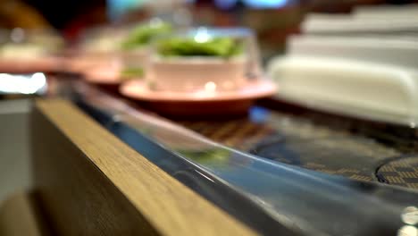 Little-girl-eats-sushi-at-a-Japanese-restaurant.-The-little-girl-is-wearing-a-hearing-aid.