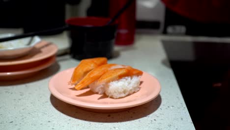 Das-kleine-Mädchen-isst-Sushi-in-einem-japanischen-Restaurant.-Das-kleine-Mädchen-trägt-ein-Hörgerät.