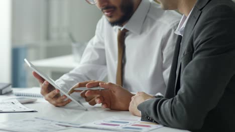 Close-Up-of-Two-Businessmen-Using-Tablet-and-Having-Discussion