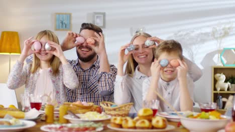 Familia-sonriente-sosteniendo-huevos-sobre-los-ojos