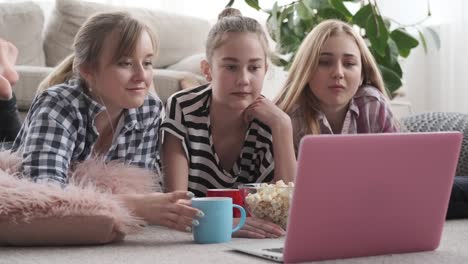 Teenager-Girls,-die-Medieninhalte-auf-dem-Laptop-beobachten,-während-sie-Snacks-zu-Hause-haben