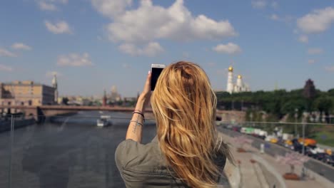 girl-takes-pictures-on-the-phone-city-Moscow-from-the-bridge