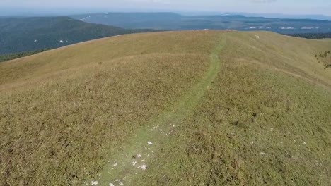 Flying-over-a-dirt-road-in-a-hill-in-a-mountainous-area.