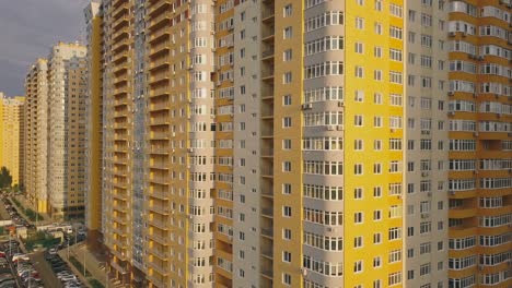 Aerial-view-of-the-facade-of-a-residential-apartment-building-under-construction.-High-rise-building-with-windows-and-balconies.-Construction-industry.-Urbanization